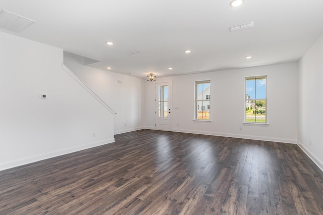 unfurnished living room with baseboards, visible vents, dark wood-type flooring, and recessed lighting