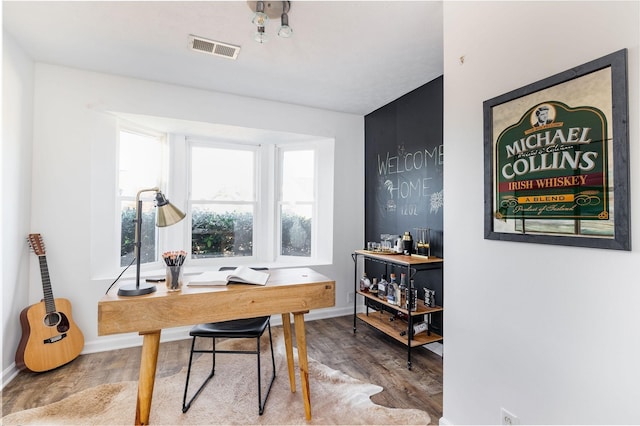 home office with visible vents, baseboards, and wood finished floors