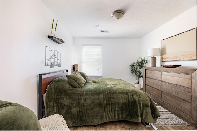 bedroom with visible vents and wood finished floors