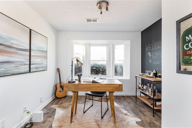 office area featuring visible vents, baseboards, and wood finished floors