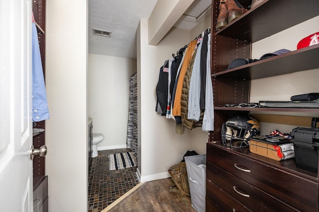 spacious closet featuring visible vents and wood finished floors