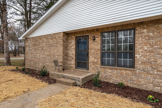 view of exterior entry featuring brick siding