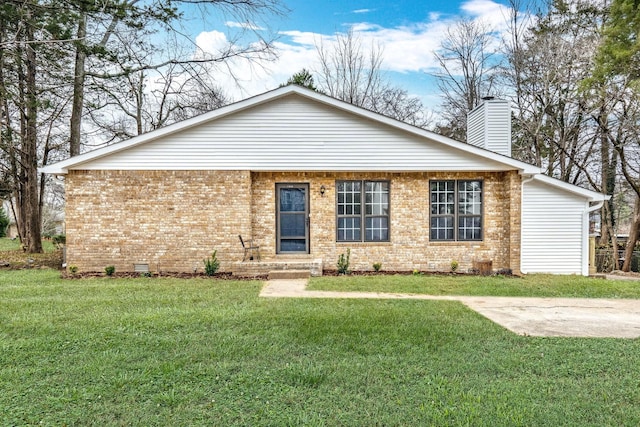 view of front of house featuring crawl space, brick siding, a chimney, and a front yard