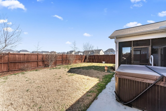 view of yard featuring a sunroom and a fenced backyard