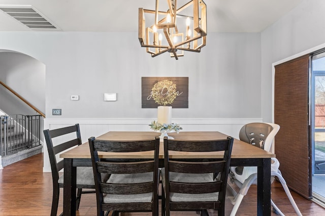 dining area with stairs, wainscoting, wood finished floors, and visible vents