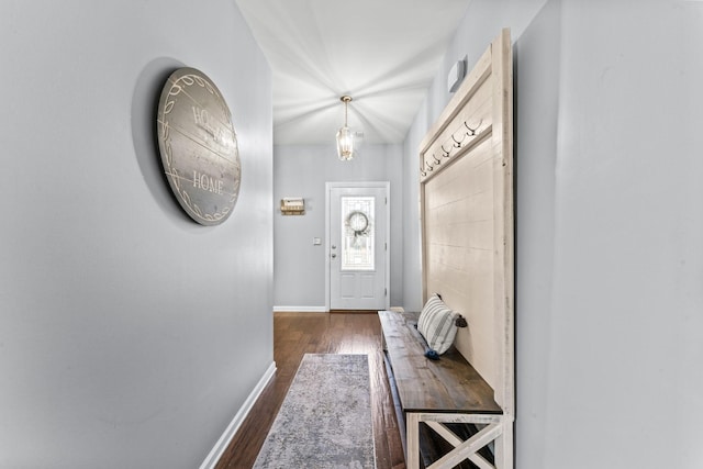 doorway with dark wood-style flooring and baseboards