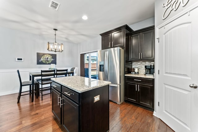 kitchen featuring visible vents, decorative backsplash, dark wood-style floors, a kitchen island, and stainless steel refrigerator with ice dispenser