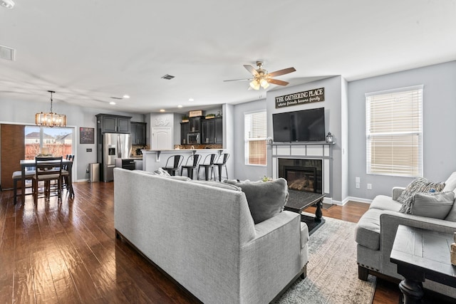 living area with dark wood-style floors, a wealth of natural light, and baseboards