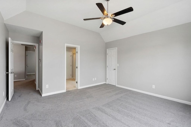 unfurnished bedroom with light carpet, ceiling fan, baseboards, and vaulted ceiling