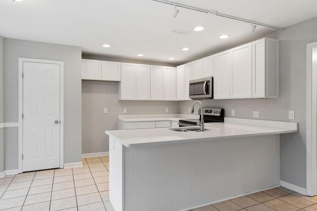 kitchen featuring white cabinetry, stainless steel microwave, light countertops, and a sink