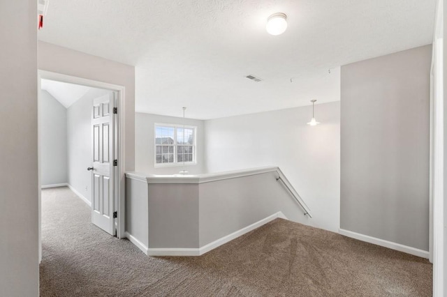 corridor with baseboards, visible vents, an upstairs landing, and light colored carpet