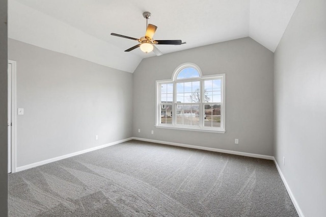 carpeted empty room featuring lofted ceiling, ceiling fan, and baseboards