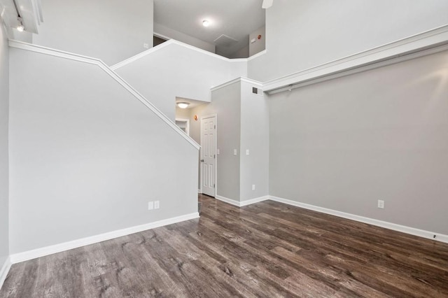 unfurnished living room featuring high vaulted ceiling, dark wood-style flooring, visible vents, and baseboards