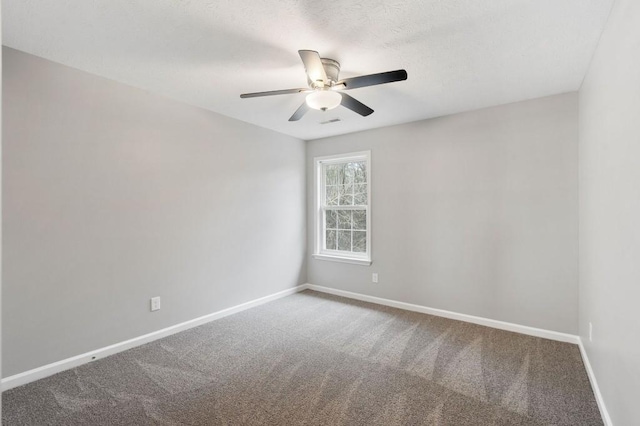 spare room with carpet, visible vents, baseboards, and a ceiling fan