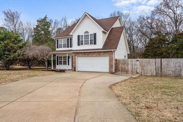 view of front of home with a front yard, concrete driveway, brick siding, and fence