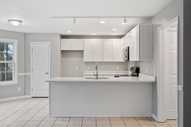 kitchen featuring a sink, white cabinetry, light countertops, and electric range oven