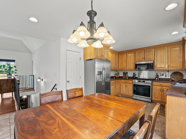 kitchen featuring dark countertops, appliances with stainless steel finishes, a notable chandelier, and recessed lighting