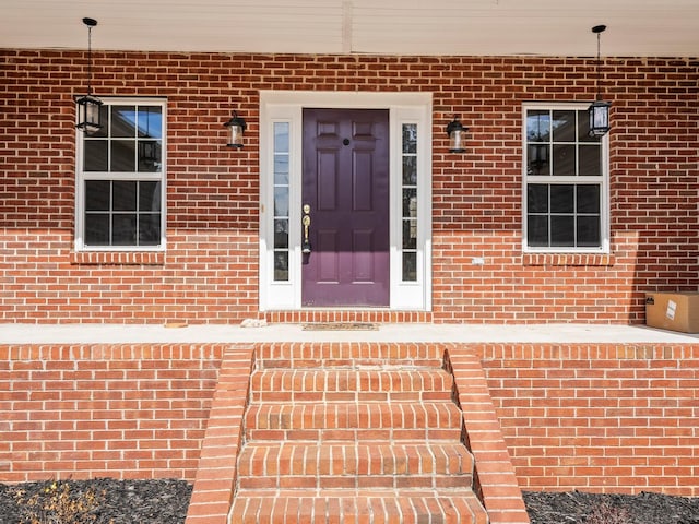 entrance to property featuring brick siding