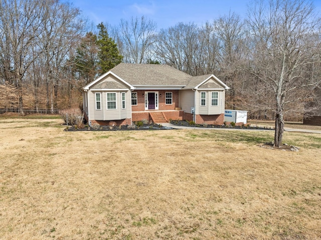 ranch-style home with a front lawn, roof with shingles, fence, and brick siding