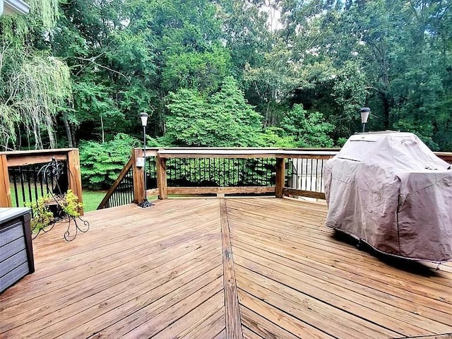 deck featuring grilling area and a view of trees