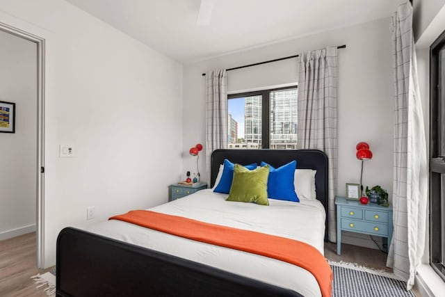 bedroom featuring ceiling fan, baseboards, and wood finished floors