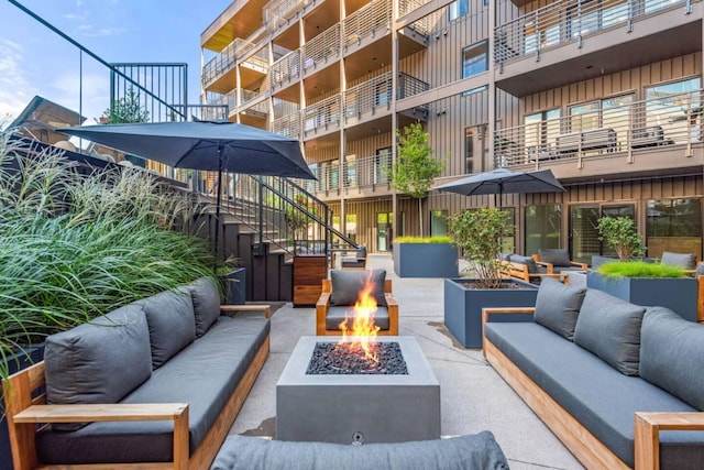 exterior space featuring an outdoor living space with a fire pit and stairs