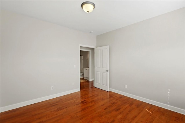 empty room featuring baseboards and wood finished floors