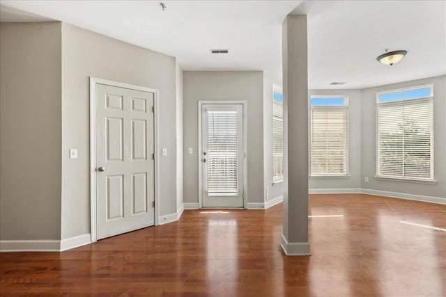 entrance foyer featuring visible vents, baseboards, and wood finished floors