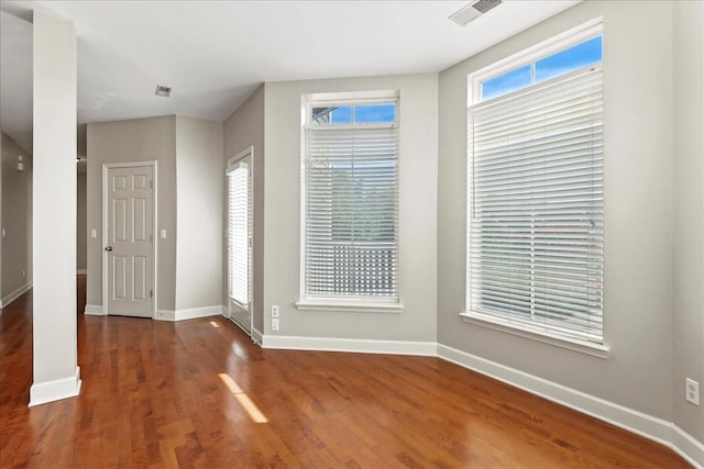 interior space with visible vents, baseboards, and wood finished floors