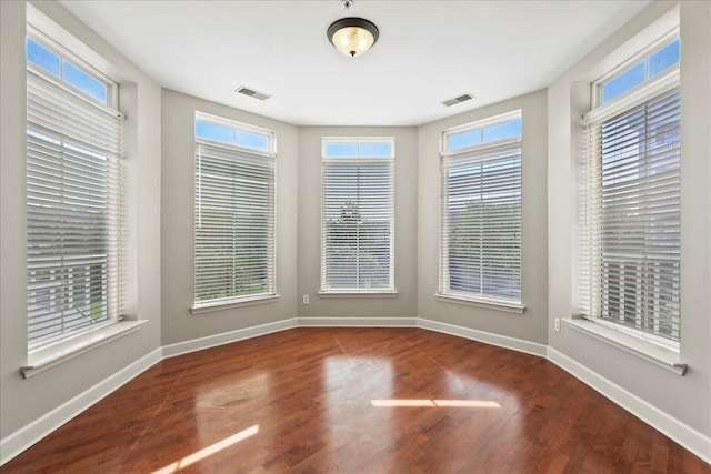 interior space with wood finished floors, visible vents, and baseboards