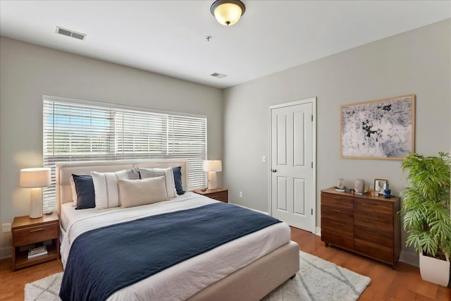 bedroom with visible vents and wood finished floors