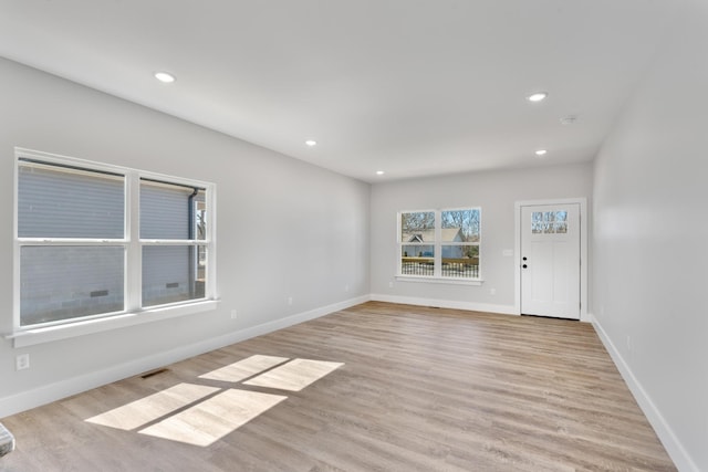 interior space with light wood-style floors, recessed lighting, visible vents, and baseboards