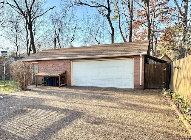 garage with concrete driveway and fence