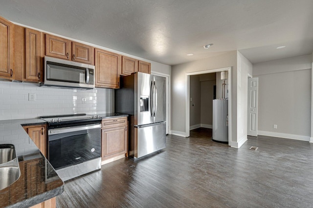 kitchen with gas water heater, brown cabinets, dark wood finished floors, backsplash, and appliances with stainless steel finishes