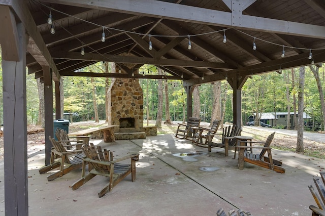 view of patio / terrace featuring a gazebo and an outdoor stone fireplace