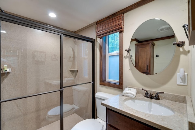 bathroom with toilet, a stall shower, and vanity