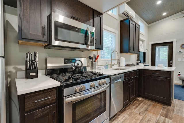 kitchen with a sink, light wood-style floors, light countertops, appliances with stainless steel finishes, and a wall mounted AC