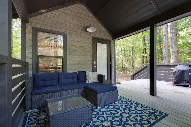 wooden terrace with a grill and an outdoor living space