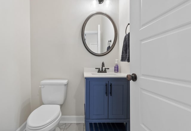 half bath featuring marble finish floor, toilet, vanity, and baseboards