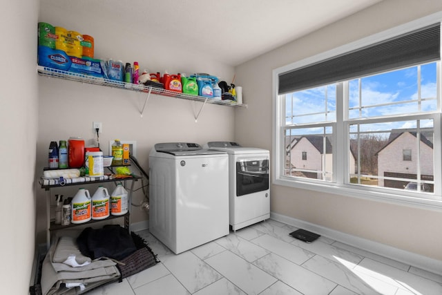 clothes washing area featuring baseboards, marble finish floor, laundry area, and washer and dryer