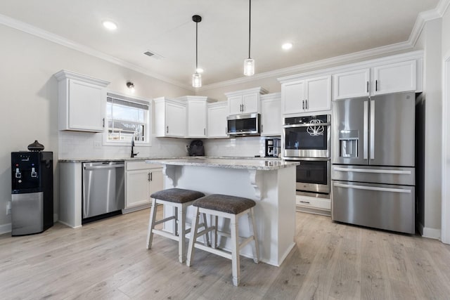 kitchen with tasteful backsplash, appliances with stainless steel finishes, white cabinetry, and light wood-style floors