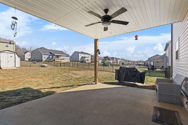 view of patio with a shed, a residential view, a playground, and a fenced backyard