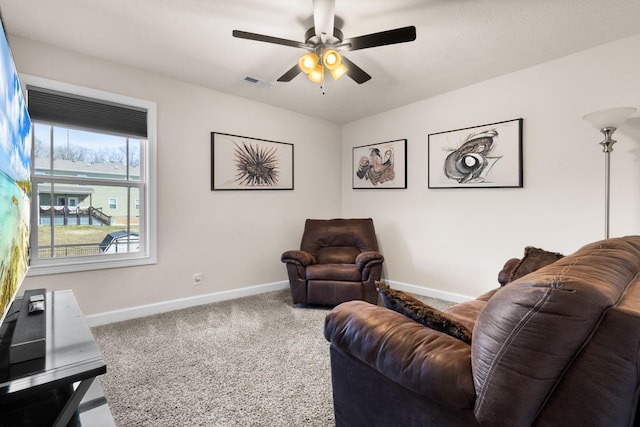 living area featuring a ceiling fan, baseboards, visible vents, and carpet flooring