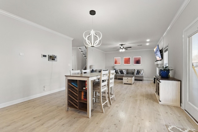 kitchen with ceiling fan with notable chandelier, baseboards, hanging light fixtures, light wood finished floors, and crown molding