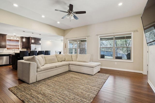 living room featuring dark wood-style floors, recessed lighting, and baseboards