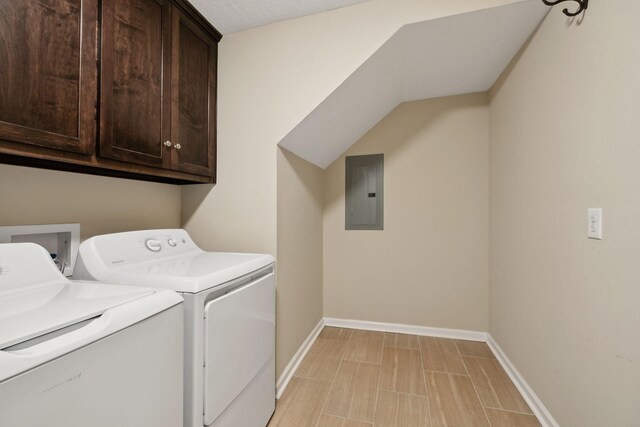 washroom with cabinet space, washing machine and clothes dryer, electric panel, and baseboards