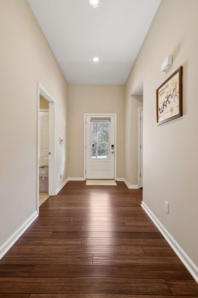 doorway with dark wood-style floors and baseboards