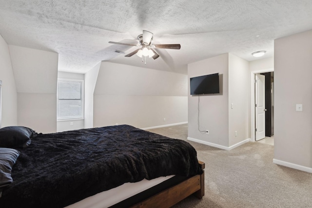 bedroom with light colored carpet, a ceiling fan, vaulted ceiling, a textured ceiling, and baseboards