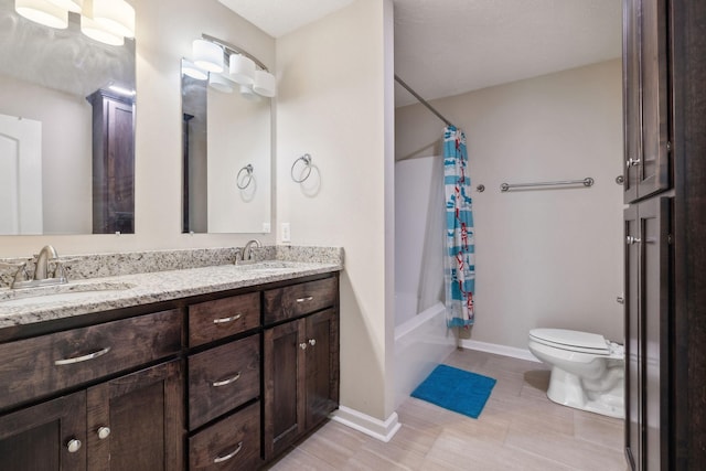 full bath featuring double vanity, shower / tub combo, a sink, and toilet