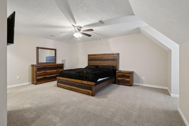 bedroom with baseboards, light colored carpet, visible vents, and a textured ceiling